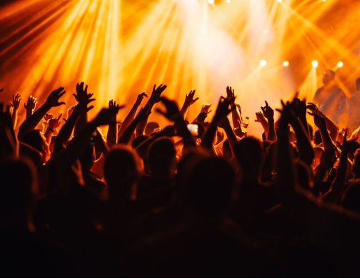 The silhouette of a group of people dancing at an open air concert